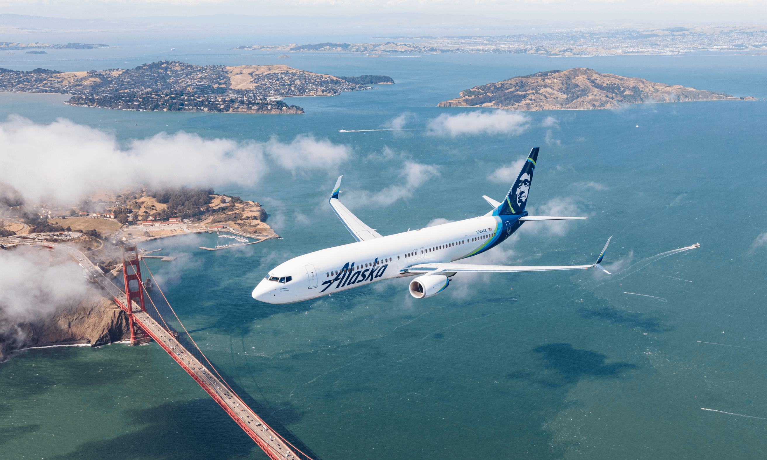 Alaska Airlines airplane flying over the San Francisco Golden Gate Bridge